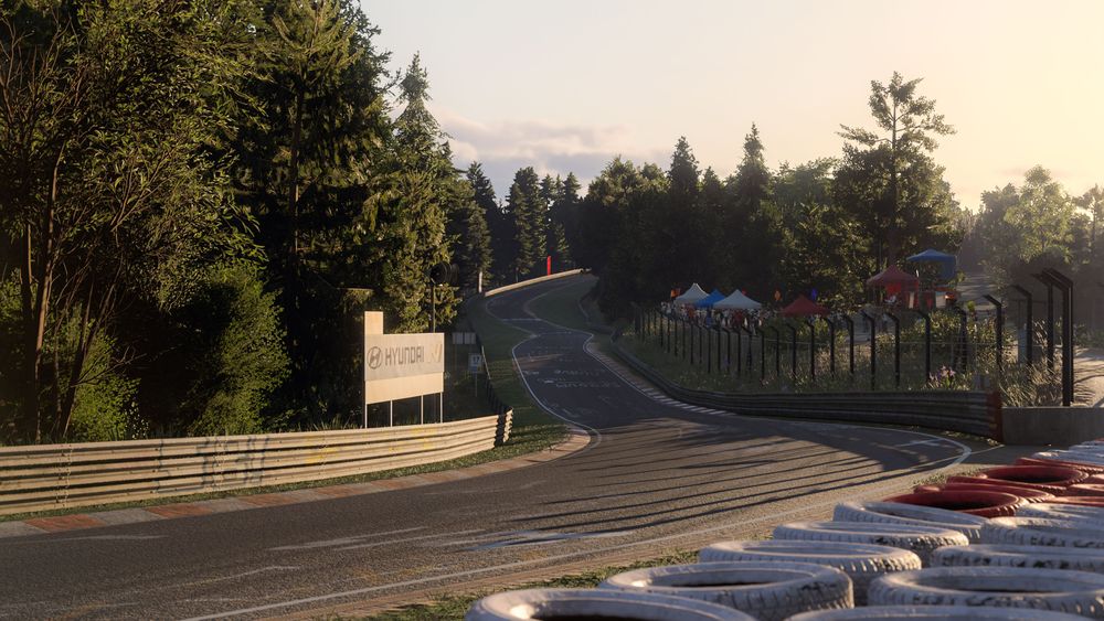 A corner section of the Nordschleife surrounded by trees and a tire wall