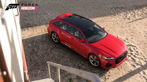 A red Audi RS 6 Avant parked on a beach