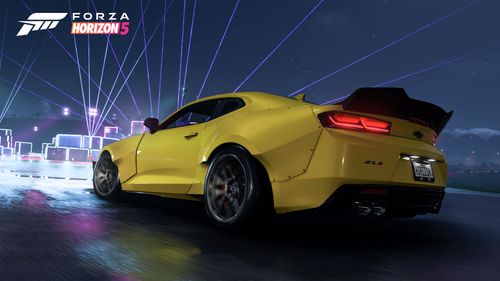 A yellow 2018 Chevrolet Camaro ZL1 1LE fitted in the StreetFighter LA as it drives towards the neon-infused Street Scene Festival Outpost.