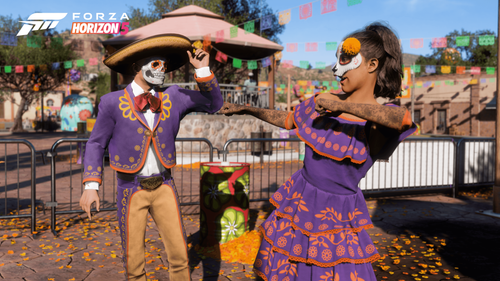 A couple dancing and looking at each other wearing a purple suit and dress with orange details. They are both wearing skull masks