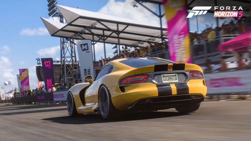 The 2013 Dodge SRT Viper GTS Anniversary Edition painted yellow with two black strips drives through the Horizon Festival.