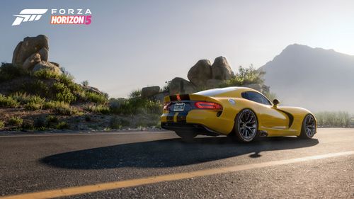 The 2013 Dodge SRT Viper GTS Anniversary Edition parked on a road by rocks and desert foliage. 