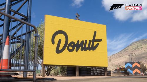 A yellow roadside sign with the Donut Media logo.