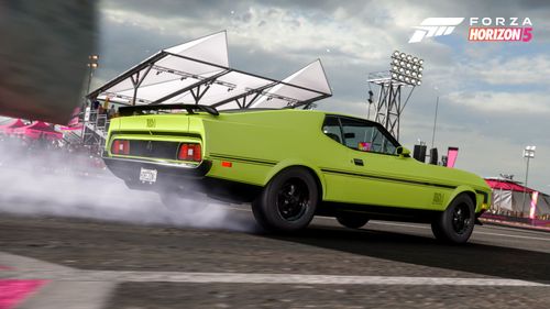 A green 1971 Ford Mustang Mach 1 lifts up some tire smoke from the tarmac as it prepares to blast down the drag strip at the Horizon Mexico Festival site.