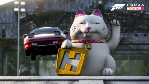 A car is seen mid-air behind a Horizon Lucky Cat prop.
