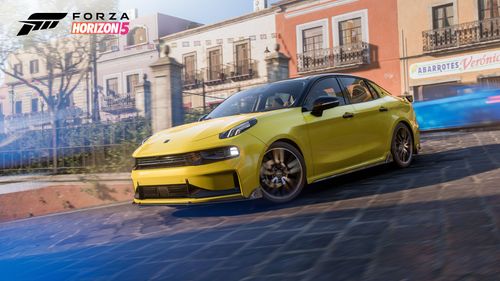 A yellow 2021 Lynk & Co 03+ turns on a road in Guanajuato with blue motion blur effects of traffic cars passing by.