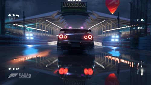 A car showing its rear lights turned on standing on a wet surface in front of a Horizon Festival outpost