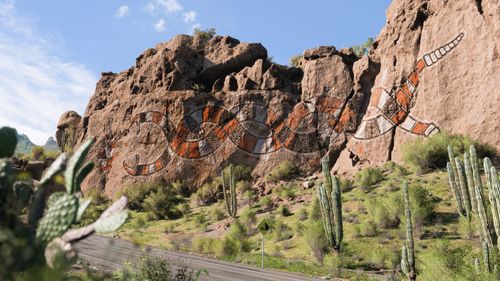 Rocky terrain engraved with an orange and white snake-shaped, Horizon-inspired mural. 