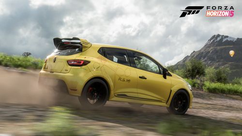 Yellow Renault Clio RS 16 Concept kicks up some dust on a dirt trail.