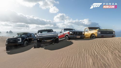 4 all-terrain vehicles on top of a sand dune