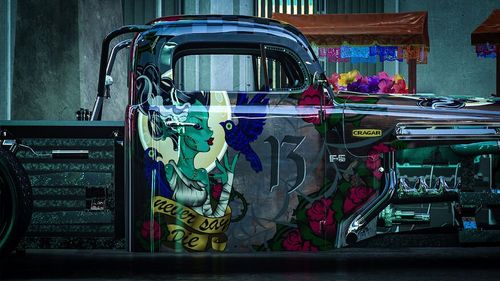 A pickup truck painted with a livery featuring characters and the number 13