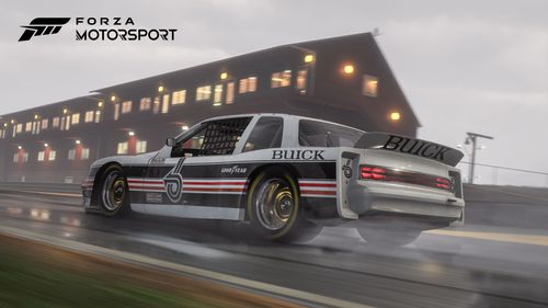 A Buick Somerset racing on a wet track in front of a crowd