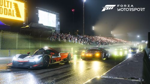 The race cars line up on the grid for the start of the event at night.