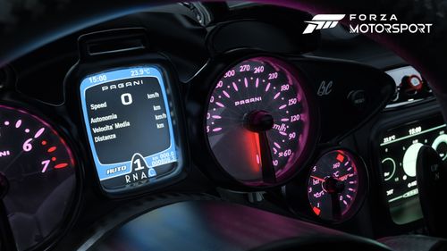Gauges inside car illuminated in blue, red and pink hues.