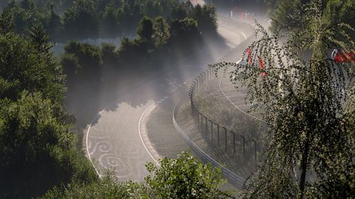The Nordschleife race track covered in mist and surrounded by trees