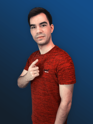 A white person with short black hair wearing a red t-shirt stands in front of a blue background, pointing slightly upwards and towards the camera.